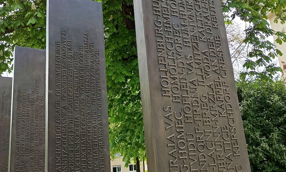 Vier Metallsäulen mit Schrift