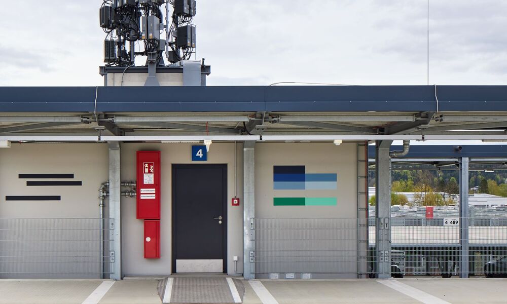 Das Foto zeigt ein Kunstwerk aus horizontalen Steifen an der Wand eines Gebäudes.