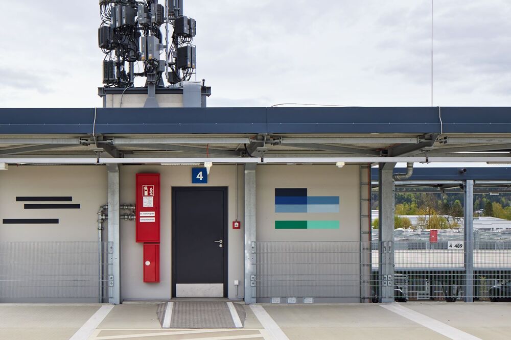 Das Foto zeigt ein Kunstwerk aus horizontalen Steifen an der Wand eines Gebäudes.