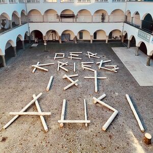 Es liegen Holzbalken im Burghof, mit dem Schriftzug der Krieg ist aus.