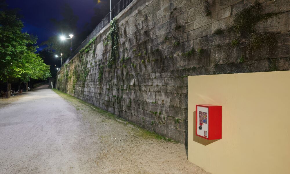 Ein nostalgischer Kaugummiautomat hängt im Lendhafen an einer beigen Wand