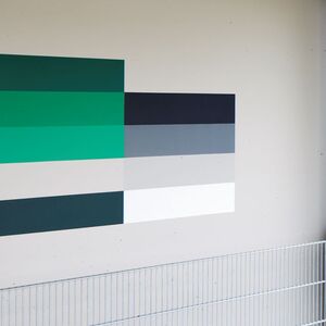 Farbeige horizontale Streifen an der Außenwand eines Gebäudes auf einem Parkdeck.