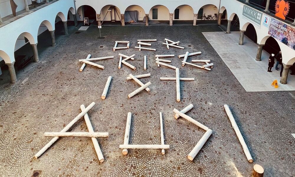 Es liegen Holzbalken im Burghof, mit dem Schriftzug der Krieg ist aus.