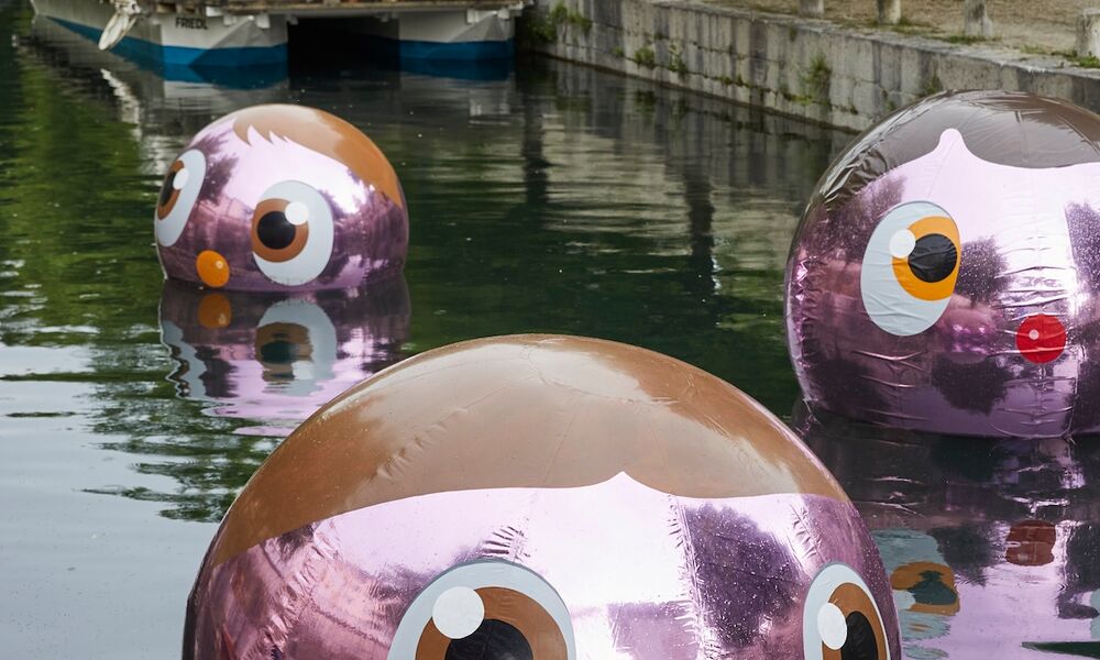 Drei rosa Kugeln mit Augen schwimmen im Wasser